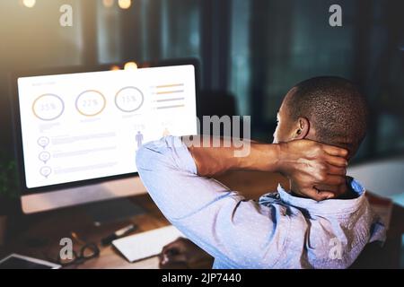 Essayer de comprendre ces chiffres. Vue arrière d'un jeune homme d'affaires méconnu qui éprouve des tensions tout en utilisant un ordinateur pour regarder Banque D'Images