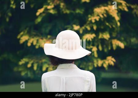 Qui pourrait que fashionista être. Vue arrière d'une femme portant un chapeau élégant à l'extérieur. Banque D'Images