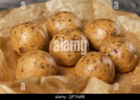 Bonbons faits maison. Farine de noix de coco au chocolat noir. Sous forme de boules. Sur papier artisanal. Banque D'Images
