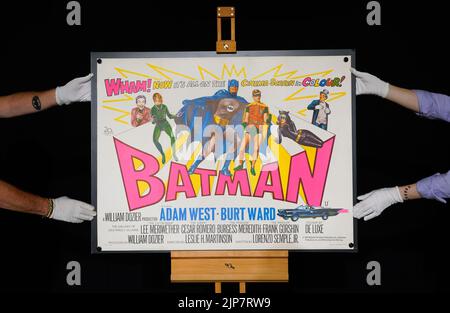 Photo précédemment non publiée du 02/08/22 des employés de Propstore ajustant une affiche britannique Quad pour le film de 1966 'Batman' (estimation £5 000 - 7 000) lors d'un aperçu de leur prochaine vente aux enchères d'affiches à leur maison de vente aux enchères à Rickmansworth, Hertfordshire. Date de publication : mardi 16 août 2022. Banque D'Images