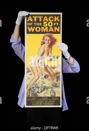 Photo non publiée précédemment en date du 02/08/22 d'un employé de Propstore tenant un encart américain du film de 1958 'Attack of the 50 foot Woman' (estimation £4 000 - 6 000) lors d'un aperçu de leur vente aux enchères d'affiches à leur maison de vente aux enchères à Rickmansworth, Hertfordshire. Date de publication : mardi 16 août 2022. Banque D'Images