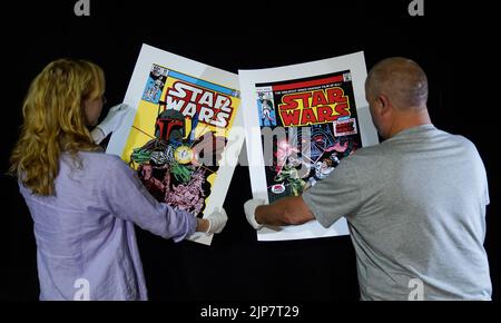 Photo non publiée du 02/08/22 d'employés de Propstore détenant deux tirages d'un jeu de six tirages Star Wars « Gillee » signés par Stan Lee, 2015 (est. £5 000 - 7 000) lors d'un aperçu de leur prochaine vente aux enchères d'affiches à leur maison de vente aux enchères à Rickmansworth, Hertfordshire. Date de publication : mardi 16 août 2022. Banque D'Images