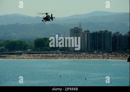 Gijon, Espagne - 24 juillet 2022. Policia Nacional (police espagnole) Eurocopter EC135 volant au-dessus de la plage de San Lorenzo pendant le festival international de l'air de Gijon Banque D'Images