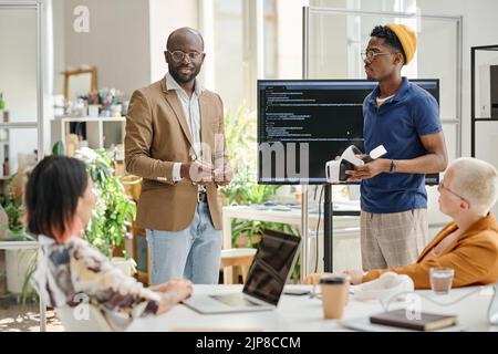 Groupe de programmeurs testant un nouveau logiciel pour les lunettes de réalité virtuelle pendant le travail d'équipe lors d'une réunion Banque D'Images