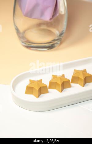 Chocolat fait main en forme d'étoile sur une assiette blanche. Produits chocolatiers faits main. Banque D'Images