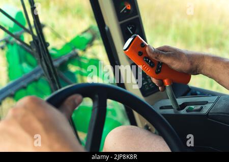 vue en gros plan des mains de l'agriculteur conduisant la moissonneuse-batteuse, tracteur contrôlant la machine. Photo de haute qualité Banque D'Images