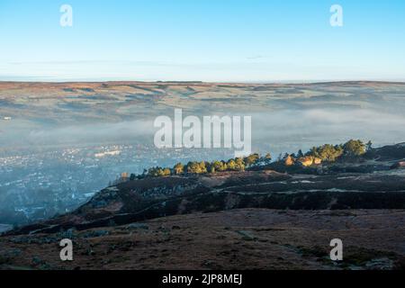 Tôt le matin, vue sur la ville d'Ilkley depuis Ilkley Moor avec une brume légère suspendue dans la vallée, West Yorkshire, Angleterre. Banque D'Images