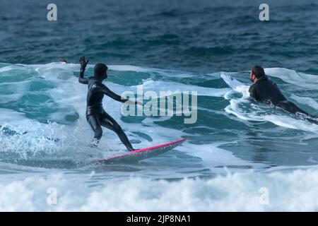 Surfeurs profitant de l'hiver surf action à Fistral à Newquay dans Cornwall au Royaume-Uni. Banque D'Images