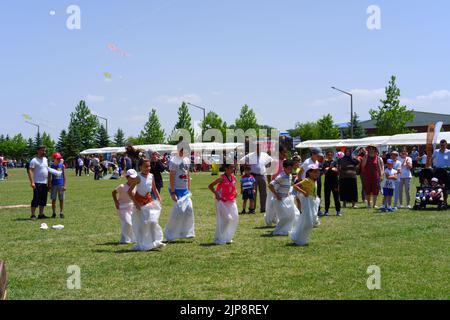 Les gens et les enfants s'amusent à la course de gunnysack en plein air en été Banque D'Images