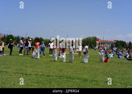 Les gens et les enfants s'amusent à la course de gunnysack en plein air en été Banque D'Images