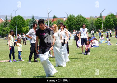 Les gens et les enfants s'amusent à la course de gunnysack en plein air en été Banque D'Images