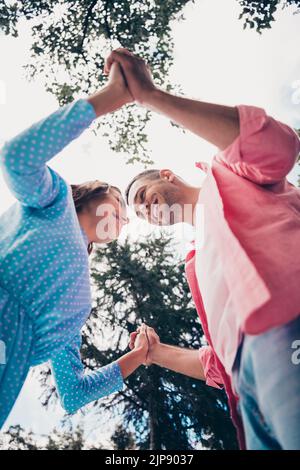 Gros plan séance photo de deux jeunes cofriend étudiants de petite amie tenir les mains ensemble dansant près de la tête de la forêt de refroidissement Banque D'Images