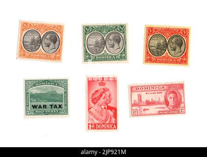 Une sélection de vieux timbres-poste à la menthe de la Dominique sur fond blanc. Banque D'Images