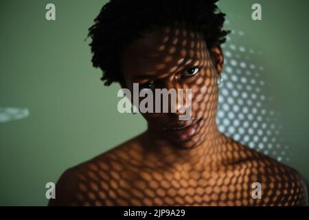 portrait d'un jeune africain américain avec des ombres sur son visage Banque D'Images