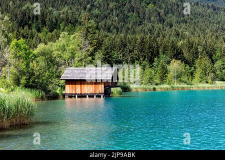 Maison traditionnelle en bois ou cabane sur la rive d'un beau lac Weissensee en carinthie, Autriche Banque D'Images