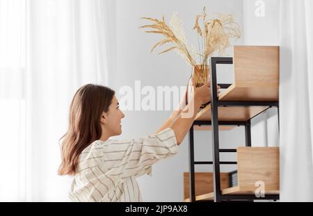femme décorant la maison avec des fleurs séchées dans un vase Banque D'Images