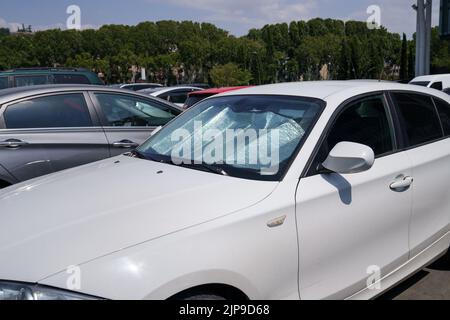 Surface réfléchissante protectrice sous le pare-brise de la voiture par temps chaud, chauffée par les rayons du soleil à l'intérieur de la voiture Banque D'Images