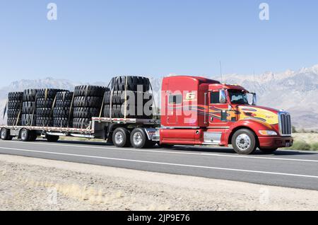 18 roues ou semi-camions illustrés transportant des pneus de très grande taille le long de l'autoroute 395 près de Lone Pine, Inyo County, Californie, États-Unis. Banque D'Images