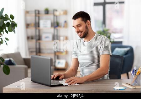 homme nettoyant l'ordinateur portable avec un chiffon humide au bureau à la maison Banque D'Images