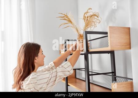 femme décorant la maison avec des fleurs séchées dans un vase Banque D'Images