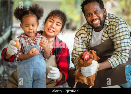 Portrait de l'homme et de la femme africains enseignant aux enfants d'élever des poulets à la ferme Banque D'Images