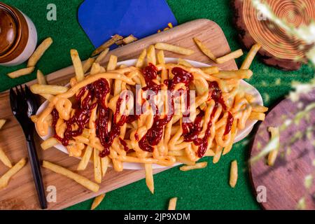 Plat de FRITES CHEESY au café-restaurant. Plat de restauration rapide américain, composé de frites recouvertes de fromage. Banque D'Images