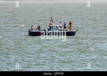 Pêcheurs en mer sur un petit bateau dans l'estuaire de la Tamise, au large de Southend on Sea, Essex, Royaume-Uni. Pêche à la ligne d'eau salée sur la Tamise Banque D'Images