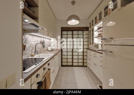 Cuisine japonaise moderne design intérieur dans des tons de terre, textures naturelles avec mobilier en bois massif en chêne et portes coulissantes en bois japonais. Conce Japandi Banque D'Images