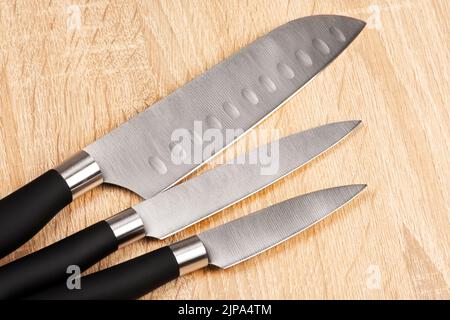 Ensemble de couteaux de cuisine en acier sur table en bois Banque D'Images