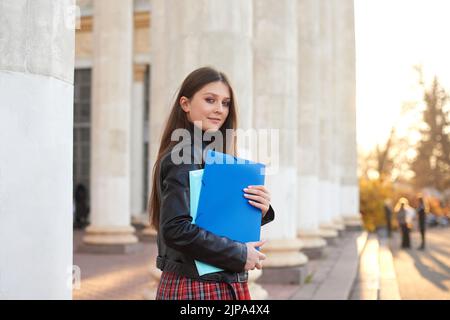 Une étudiante de retour à l'université. Femme tient des chemises bleues dans les mains. Étudier hors ligne, concept d'éducation Banque D'Images