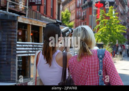 Une femme indie cinéaste avec un appareil photo Canon Zoom 318 Super 8 dans le quartier chinois/Lower East Side de Manhattan Banque D'Images