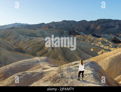 Randonneur admirant les merveilles naturelles des mauvaises terres colorées, Zabriskie point, parc national de la Vallée de la mort, Californie, Amérique du Nord, États-Unis Banque D'Images