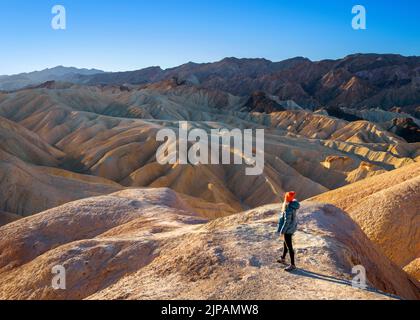 Randonneur admirant les merveilles naturelles des mauvaises terres colorées, Zabriskie point, parc national de la Vallée de la mort, Californie, Amérique du Nord, États-Unis Banque D'Images