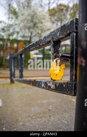 Cadenas jaune sur le montant de barrière dans une zone restreinte. Banque D'Images