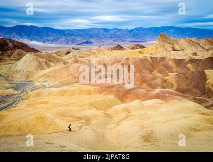 Randonneur admirant les merveilles naturelles des mauvaises terres colorées, Zabriskie point, parc national de la Vallée de la mort, Californie, Amérique du Nord, États-Unis Banque D'Images