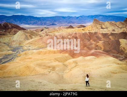 Randonneur admirant les merveilles naturelles des mauvaises terres colorées, Zabriskie point, parc national de la Vallée de la mort, Californie, Amérique du Nord, États-Unis Banque D'Images