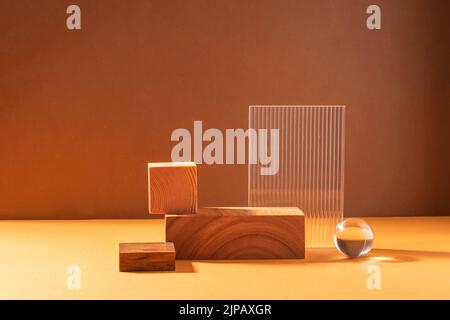 Podium abstrait créatif à partir de figures en bois et de verre, sur fond marron avec lumière dure Banque D'Images