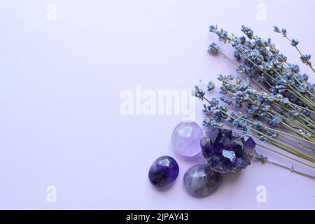 Belles pierres améthystes et druze améthyste avec un bouquet sec de lavande sur fond lilas. Amulettes magiques. Espace de copie Banque D'Images