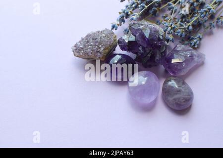 Belles pierres améthystes et druze améthyste avec un bouquet sec de lavande sur fond lilas. Amulettes magiques. Espace de copie Banque D'Images