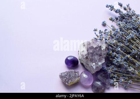 Belles pierres améthystes et druze améthyste avec un bouquet sec de lavande sur fond lilas. Amulettes magiques. Espace de copie Banque D'Images