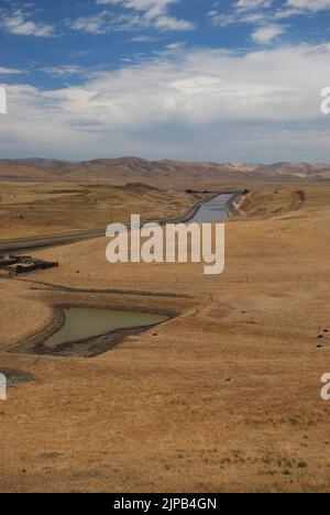 L'aqueduc de Californie près de Newman, dans le comté de Stanislaus, avec des montagnes en arrière-plan; vital pour la production agricole de la région. Banque D'Images