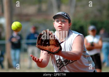 Les jeunes et les entraîneurs sur les terrains de sport pendant le printemps des sports, coachés et jouer à des jeux de filles attraper la balle de softball Banque D'Images