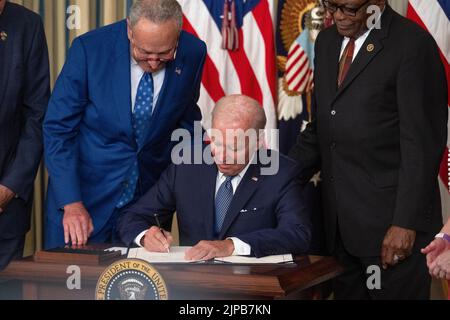 Le leader de la majorité au Sénat des États-Unis, Chuck Schumer (démocrate de New York), à gauche, Et le whip James Clyburn (démocrate de Caroline du Sud), à droite, regarde le président américain Joe Biden signe H.R. 5376, la loi de réduction de l'inflation de 2022 dans la salle à manger de l'État de la Maison Blanche à Washington, DC mardi, 16 août 2022. Le projet de loi vise à réduire le coût de l'énergie, des médicaments d'ordonnance et d'autres soins de santé pour les familles américaines, à combattre la crise climatique, à réduire le déficit et à faire payer les impôts aux plus grandes sociétés.Credit: Ron Sachs/CNP/MediaPunch Banque D'Images