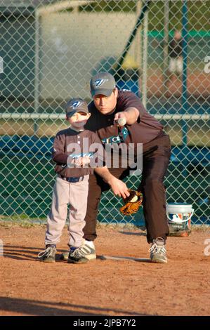 Jeunes et entraîneurs sur les terrains de sport pendant les sports de printemps, étant entraînés et jouant, matchs de baseball Banque D'Images