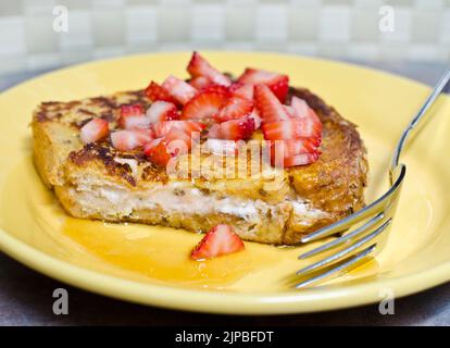 Pain grillé farci au fromage à la crème aux fraises avec des fraises fraîches et du sirop d'érable. Banque D'Images