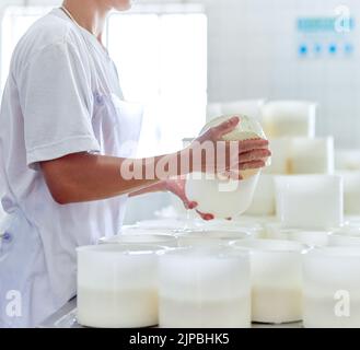 Les préparer pour l'emballage. Une femme méconnaissable travaillant dans une fromagerie. Banque D'Images