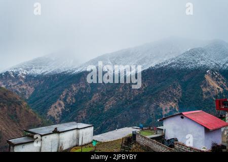 Uttarakhand. Inde. 23rd Jan2022.Un beau village de tir avec des montagnes couvertes de neige de l'himalaya dans le district d'Okhimath de Chamoli garhwal. Banque D'Images