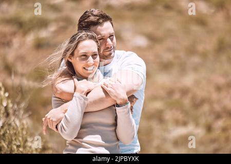 Amour, romantisme et rencontres avec un jeune couple affectueux qui enserre, enjoint et passe du temps ensemble à l'extérieur. Homme heureux, aimant et souriant et Banque D'Images