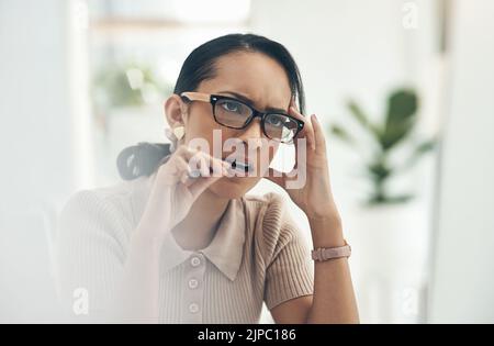 Sérieuse, pensant et confuse femme d'affaires piquant son stylo, se sentant nerveux et essayant de résoudre un problème. Les femmes d'affaires professionnel en difficulté Banque D'Images