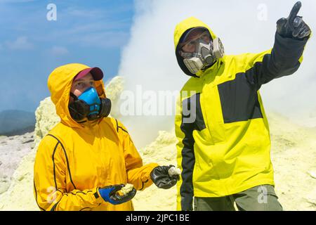 les volcans sur la pente du volcan collectent des échantillons de minéraux sur fond de fumaroles de soufre Banque D'Images